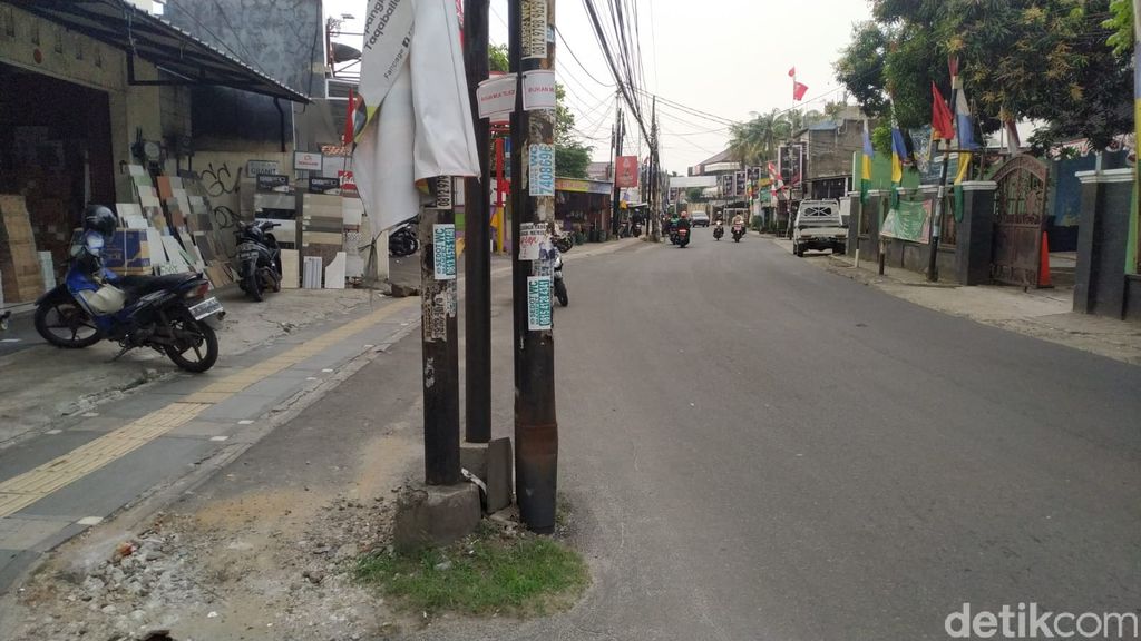 Tiang-tiang makan jalan di Jl WR Supratman, sebagian ditandai dengan tulisan 'bukan milik Telkom'. 30 Agustus 2021. (Athika Rahma/detikcom)