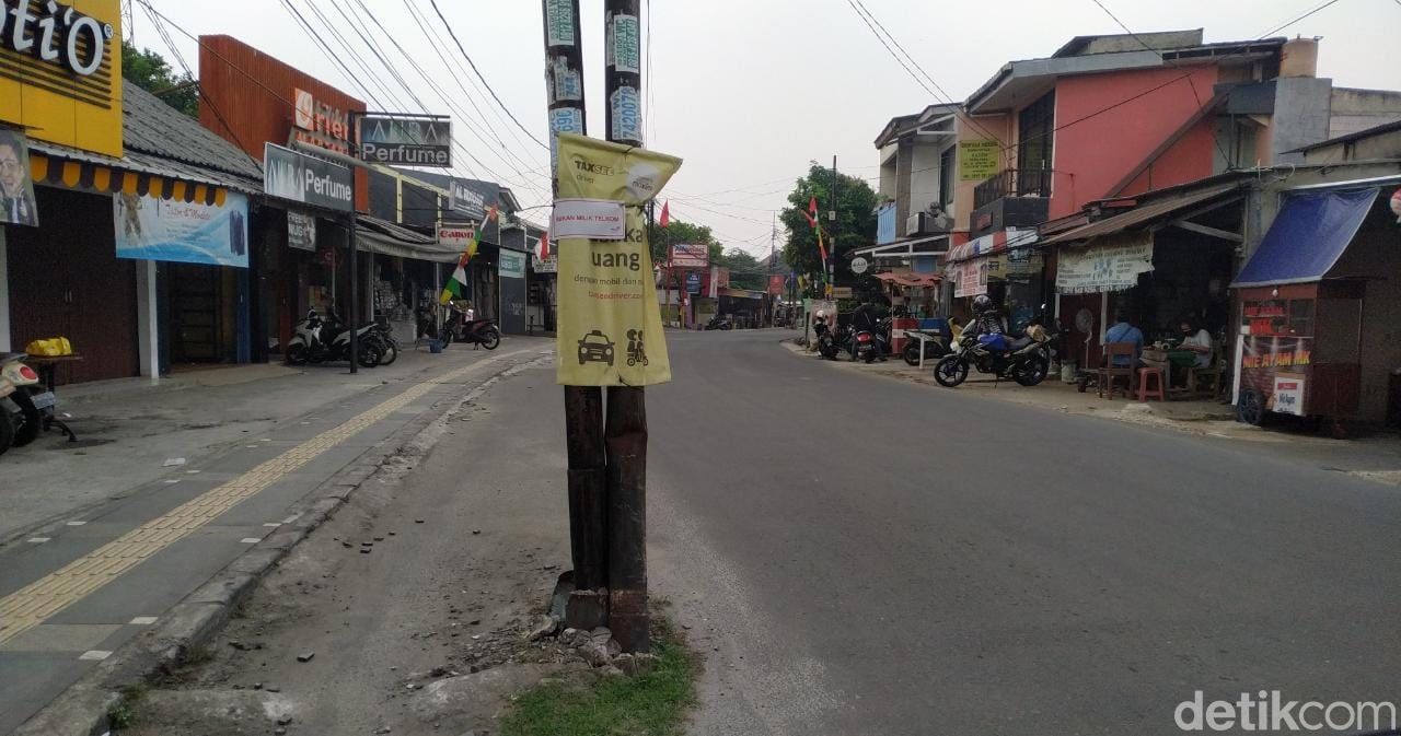 Tiang-tiang makan jalan di Jl WR Supratman, sebagian ditandai dengan tulisan 'bukan milik Telkom'. 30 Agustus 2021. (Athika Rahma/detikcom)