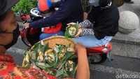 Seusai menyampaikan aksi, massa membagikan nasi bancakan kepada pengendara yang melintas.