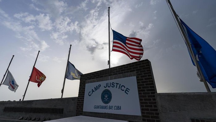 In this photo reviewed by U.S. military officials, flags fly at half-staff in honor of the U.S. service members and other victims killed in the terrorist attack in Kabul, Afghanistan, at Camp Justice, Sunday, Aug. 29, 2021, in Guantanamo Bay Naval Base, Cuba. Camp Justice is where the military commission proceedings are held for detainees charged with war crimes. (AP Photo/Alex Brandon)