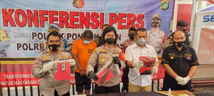 Kapolsek Pondok Aren, Kompol Riza Sativa, memegang barang bukti preman berinisial E, preman ada di belakang berbaju tahanan warna oranye. (Dok Istimewa)