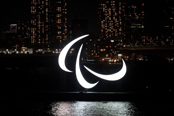 A general view shows the Paralympics symbol rings lit up at night on the Odaiba waterfront in Tokyo on August 21, 2021. (Photo by Charly TRIBALLEAU / AFP)
