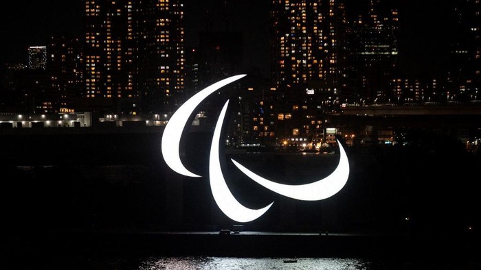 A general view shows the Paralympics symbol rings lit up at night on the Odaiba waterfront in Tokyo on August 21, 2021. (Photo by Charly TRIBALLEAU / AFP)