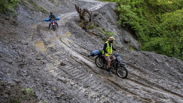 Sejumlah pengendara melitas di ruas Jalan Trans Palu-Kulawi yang tertimbun material longsoran di Desa Salua, Sigi, Sulawesi Tengah, Selasa (31/8/2021). Jalan yang menghubungkan Kota Palu dan Kabupaten Sigi itu tertimbun material longsoran di lima titik sejak 28 Agustus lalu akibat hujan deras dengan intensitas tinggi dan hingga kini hanya bisa dilalui oleh kendaraan roda dua. ANTARA FOTO/Basri Marzuki/hp.