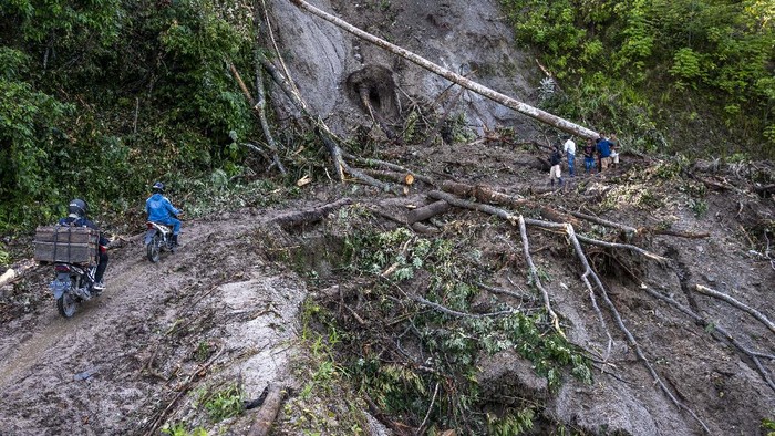Sejumlah pengendara melitas di ruas Jalan Trans Palu-Kulawi yang tertimbun material longsoran di Desa Salua, Sigi, Sulawesi Tengah, Selasa (31/8/2021). Jalan yang menghubungkan Kota Palu dan Kabupaten Sigi itu tertimbun material longsoran di lima titik sejak 28 Agustus lalu akibat hujan deras dengan intensitas tinggi dan hingga kini hanya bisa dilalui oleh kendaraan roda dua. ANTARA FOTO/Basri Marzuki/hp.