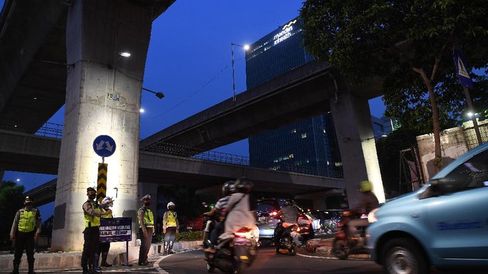 PEMERINTAH PERPANJANG PPKM HINGGA 6 SEPTEMBER Anggota Polisi dan Dishub mengatur arus lalu-lintas di pos pengendalian mobilitas ganjil-genap kendaraan, Mampang Prapatan, Jakarta Selatan, Senin (30/8/2021). Pemerintah memperpanjang PPKM level 3 dan 4 di Jawa-Bali hingga 6 September 2021. ANTARA FOTO/Sigid Kurniawan/wsj.