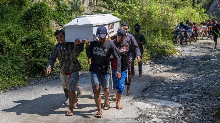 Warga memikul peti jenazah melintasi jalan Trans Palu-Kulawi yang sebagiannya tertimbun material longsoran di Desa Salua, Sigi, Sulawesi Tengah, Selasa (31/8/2021). Jenazah tersebut terpaksa dipikul untuk pemakaman di desa asalnya di Desa Anca, Kecamatan Lindu yang berjarak lebih dari 25 kilometer karena akses jalan utama tidak dapat dilalui kendaraan roda empat akibat longsor yang menimbun jalan sejak 28 Agustus lalu. ANTARA FOTO/Basri Marzuki/hp.