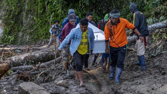 PIKUL JENAZAH HINGGA 25 KILOMETER Warga memikul peti jenazah melintasi jalan Trans Palu-Kulawi yang sebagiannya tertimbun material longsoran di Desa Salua, Sigi, Sulawesi Tengah, Selasa (31/8/2021). Jenazah tersebut terpaksa dipikul untuk pemakaman di desa asalnya di Desa Anca, Kecamatan Lindu yang berjarak lebih dari 25 kilometer karena akses jalan utama tidak dapat dilalui kendaraan roda empat akibat longsor yang menimbun jalan sejak 28 Agustus lalu. ANTARA FOTO/Basri Marzuki/hp.