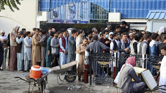 Potret Warga Afghanistan Antre Berjam-jam Demi Ambil Uang di Bank Warga berdatangan untuk melakukan penarikan uang tunai usai bank di Afghanistan kembali beroperasi. Demi ambil uang, warga rela antre berjam-jam.
