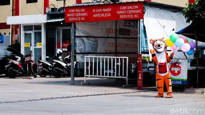 Seorang warga menjadi badut sambil menjual balon di depan SPBU. Dia menjual balon dengan harga seikhlasnya.
