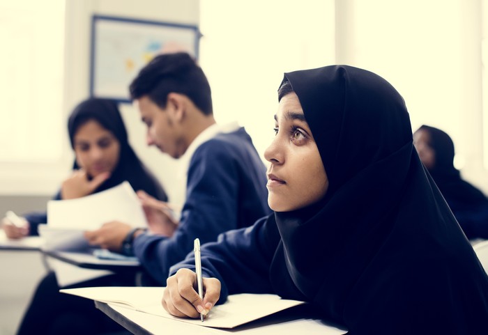 Diverse Muslim children studying in classroom