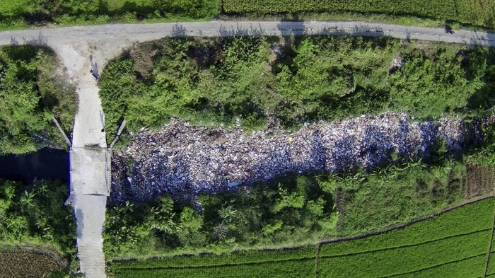 ALIRAN KALI BUSA DIPENUHI SAMPAH Foto udara aliran Kali Busa dipenuhi sampah plastik di Tambun Utara, Kabupaten Bekasi, Jawa Barat, Rabu (1/9/2021). Menurut warga tumpukan sampah sepanjang 200 meter yang berasal dari limbah rumah tangga sudah berada di aliran kali tersebut selama enam bulan. ANTARA FOTO/Fakhri Herrmansyah/rwa.