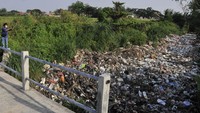 Warga mengamati aliran Kali Busa yang dipenuhi sampah plastik di Tambun Utara, Kabupaten Bekasi, Jawa Barat, Rabu (1/9/2021). 