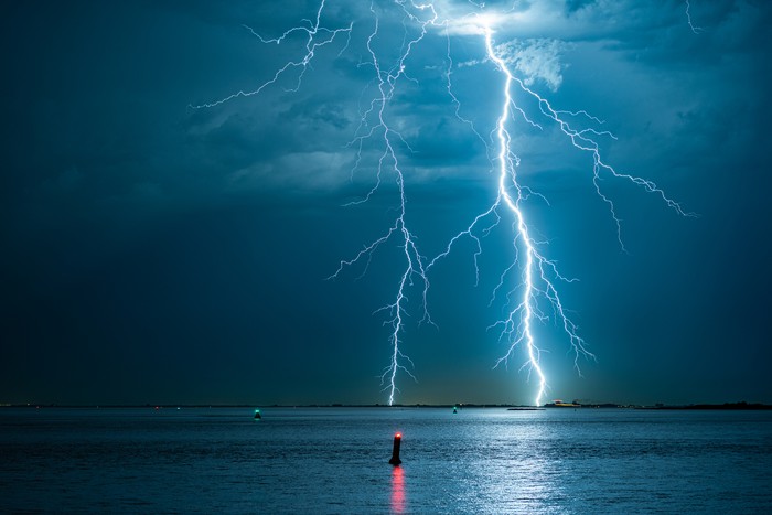 Violent lightning bolts strike the water off the Dutch coast.
