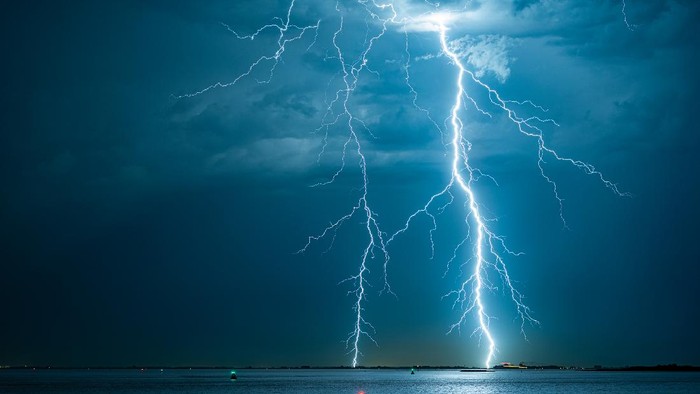 Violent lightning bolts strike the water off the Dutch coast.