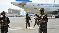 Anggota unit militer Taliban Badri 313 berjaga di samping pesawat Angkatan Udara Afghanistan di bandara di Kabul pada 31 Agustus 2021. AFP/WAKIL KOHSAR