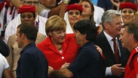 Merkel memberi selamat kepada pelatih timnas Jerman Joachim Loew usai meraih Piala Dunia sepakbola di Rio De Jeneiro, Brazil (13/7/2014). (Clive Rose/Getty Images)