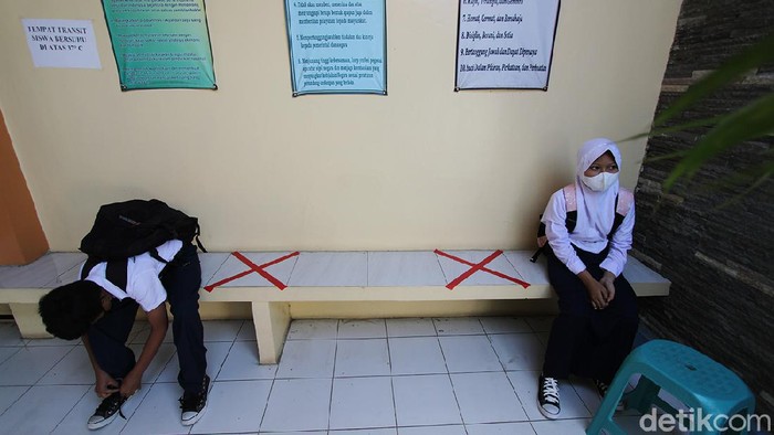 Pelajar SLTPN 22 Solo melaksanakan pembelajaran tatap muka dengan guru di ruang sekolah, Solo, Jawa Tengah, Kamis (2/9). Sekolah tersebut menerapkan aturan kehadiran 50 persen pelajar dan membatasi waktu tatap muka dari pukul 07.30 hingga 09.00 WIB dengan pemberlakuan protokol kesehatan ketat.