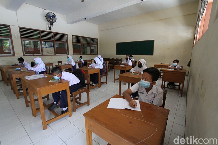 Pelajar SLTPN 22 Solo melaksanakan pembelajaran tatap muka dengan guru di ruang sekolah, Solo, Jawa Tengah, Kamis (2/9). Sekolah tersebut menerapkan aturan kehadiran 50 persen pelajar dan membatasi waktu tatap muka dari pukul 07.30 hingga 09.00 WIB dengan pemberlakuan protokol kesehatan ketat.