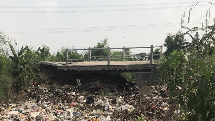 Jembatan Kali Busa ambruk, hal itu yang diduga jadi penyebab sampah menumpuk.