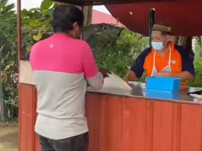 kurir makanan bantu penjual roti canai yang sedang sibuk siapkan pesanan