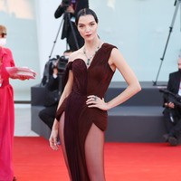 Model Italia Mariacarla Boscono memilih gaun merah anggur yang memiliki belahan di kedua sisi roknya. (Foto: Getty Images/Marc Piasecki)