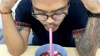 Coki punya cara unik menikmati es campur. Bukan dengan sendok, ia meminum air esnya dulu dengan sedotan. Slurpp!