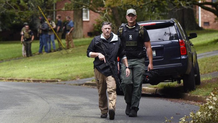 Law enforcement officers search the Foxhall neighborhood behind Mount Tabor High School in Winston-Salem, N.C., after a shooting that left one student dead, Wednesday, Sept. 1, 2021. (Walt Unks/The Winston-Salem Journal via AP)