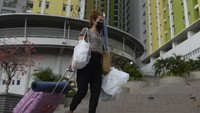 Seorang tenaga kesehatan membawa barang pribadinya keluar dari Rusun Pasar Rumput, Manggarai, Jakarta, Kamis (2/9/2021).