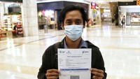 Seorang peserta menunjukan sertifikat vaksin.