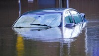 Banjir menenggelamkan mobil-mobil dan memaksa pemadam kebakaran untuk menyelamatkan ratusan orang. AP Photo/Matt Rourke.