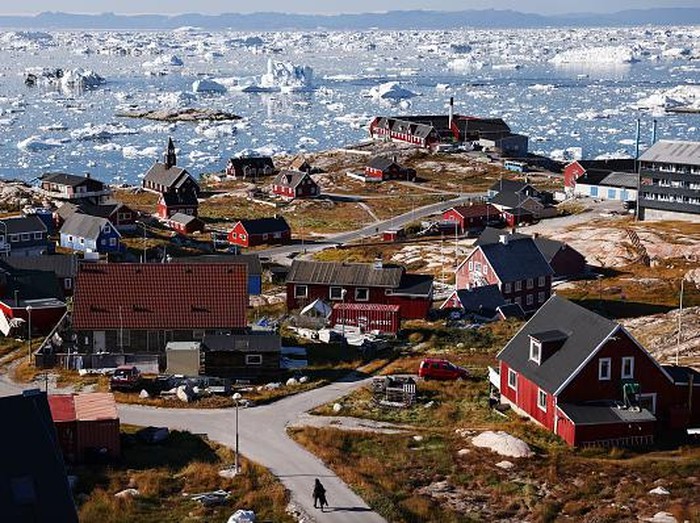 ILULISSAT, GREENLAND - SEPTEMBER 02: A pedestrian walks as ice and icebergs float in Disko Bay on September 02, 2021 in Ilulissat, Greenland. Greenland in 2021 is experiencing one of its biggest ice-melt years in recorded history. Scientists studying the Greenland Ice Sheet observed rainfall on the highest point in Greenland for the first time ever this August. Researchers from Denmark estimated that in July of this year enough ice melted on the Greenland Ice Sheet to cover the entire state of Florida with two inches of water. The observations come on the heels of the recent United Nations report on global warming which stated that accelerating climate change is driving an increase in extreme weather events. (Photo by Mario Tama/Getty Images)
