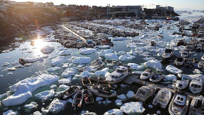 ILULISSAT, GREENLAND - SEPTEMBER 02: A pedestrian walks as ice and icebergs float in Disko Bay on September 02, 2021 in Ilulissat, Greenland. Greenland in 2021 is experiencing one of its biggest ice-melt years in recorded history. Scientists studying the Greenland Ice Sheet observed rainfall on the highest point in Greenland for the first time ever this August. Researchers from Denmark estimated that in July of this year enough ice melted on the Greenland Ice Sheet to cover the entire state of Florida with two inches of water. The observations come on the heels of the recent United Nations report on global warming which stated that accelerating climate change is driving an increase in extreme weather events. (Photo by Mario Tama/Getty Images)