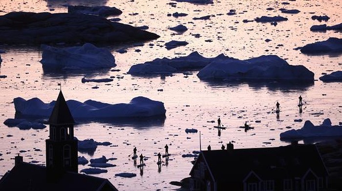 Es di Greenland Terus Cair, Sinyal Memburuknya Pemanasan Global ILULISSAT, GREENLAND - SEPTEMBER 02: A pedestrian walks as ice and icebergs float in Disko Bay on September 02, 2021 in Ilulissat, Greenland. Greenland in 2021 is experiencing one of its biggest ice-melt years in recorded history. Scientists studying the Greenland Ice Sheet observed rainfall on the highest point in Greenland for the first time ever this August. Researchers from Denmark estimated that in July of this year enough ice melted on the Greenland Ice Sheet to cover the entire state of Florida with two inches of water. The observations come on the heels of the recent United Nations report on global warming which stated that accelerating climate change is driving an increase in extreme weather events. (Photo by Mario Tama/Getty Images)