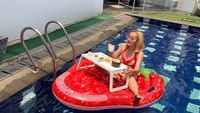 Indah Sari menikmati hidangan ala floating breakfast di kolam renang rumahnya. Gaya candid sambil memegang gelas menjadi andalannya. Foto: Instagram @indahsariofficial