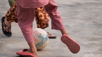Cukup dengan bola plastik, mereka asyik larut dalam permainan.