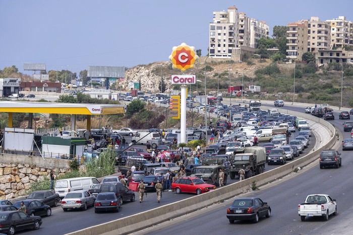 A general view of a petrol station on the main highway that links the Capital Beirut to south Lebanon, as cars come from every direction to try and fill their tanks with gasoline, in the coastal town of Jiyeh, south of Beirut, Lebanon, Friday, Sept. 3, 2021.  Lebanon is mired in a devastating economic and financial crisis, the worst in its modern history. A result of this has been crippling power cuts and severe shortages in gasoline and diesel that have been blamed on smuggling, hoarding and the cash-strapped government’s inability to secure deliveries of oil products. (AP Photo/ Hassan Ammar)