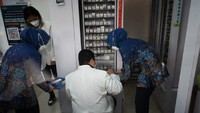 Sambil jongkok, Erick Thohir mengecek langsung obat-obat yang tersedia di Kimia Farma. Dia juga ingin memastikan bahwa ketersediaan obat tetap terjaga meskipun kasus COVID-19 telah landai.Foto: Siti Fatimah/detikcom