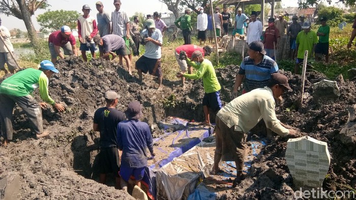 Pemakaman di Lamongan Warga memindahkan 5 peti jenazah dari makam sementara ke Tempat Pemakaman Umum (TPU) permanen di Dusun Kudu, Desa Weduni, Kecamatan Glagah, Lamongan, Jawa Timur, Sabtu (4/9).