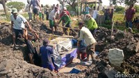 Warga memindahkan 5 peti jenazah dari makam sementara ke makam permanen di TPU Dusun Kudu, Desa Weduni, Kecamatan Glagah, Lamongan, Jawa Timur, Sabtu (4/9).