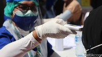 Pemeriksaan suhu tubuh sebelum menerima vaksin di One Bell Park Mall, Jakarta, Sabtu (4/9/2021).  