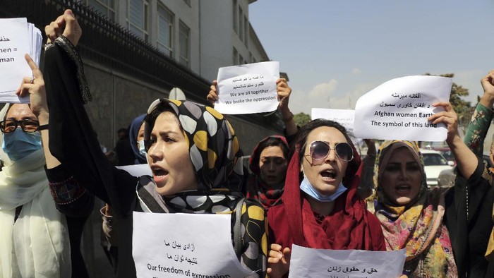 Ketika Perempuan Afghanistan Turun ke Jalan Women gather to demand their rights under the Taliban rule during a protest in Kabul, Afghanistan, Friday, Sept. 3, 2021. As the world watches intently for clues on how the Taliban will govern, their treatment of the media will be a key indicator, along with their policies toward women. When they ruled Afghanistan between 1996-2001, they enforced a harsh interpretation of Islam, barring girls and women from schools and public life, and brutally suppressing dissent. (AP Photo/Wali Sabawoon)