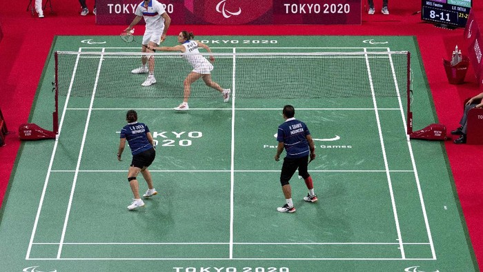 Indonesia's Hary Susanto, left, and Leani Ratri Oktila salute to the flag during the national anthem after receiving a gold medal for mixed doubles SL3-SU5 gold medal match at the Tokyo 2020 Paralympic Games, Sunday, Sept. 5, 2021, in Tokyo, Japan. (AP Photo/Kiichiro Sato)