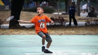 Seorang anak tampak tengah bermain bulutangkis.