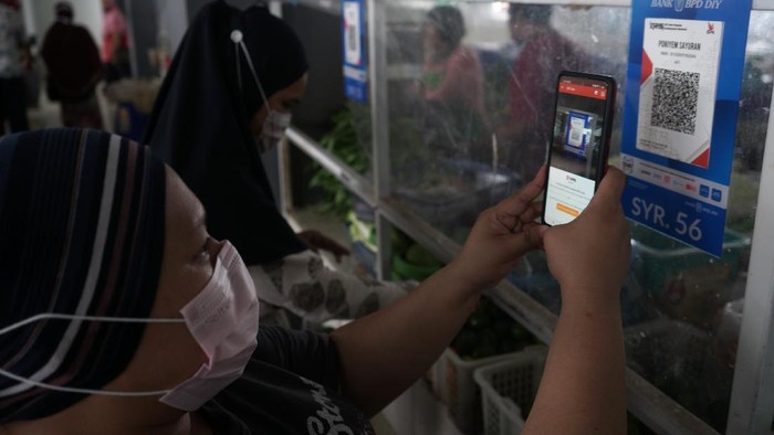 TRANSAKSI NON TUNAI DI PASAR TRADISIONAL Warga melakukan transaksi menggunakan metode bayar scan QRIS dengan aplikasi DOKU e-Wallet di Pasar Tradisional Prawirotaman, Yogyakarta, Minggu (5/9/2021). Saat ini pemerintah Yogyakarta menggencarkan transaksi non tunai di pasar tradisional seperti di Pasar Prawirotaman maupun Pasar Beringharjo. ANTARA FOTO/Andreas Fitri Atmoko/aww.