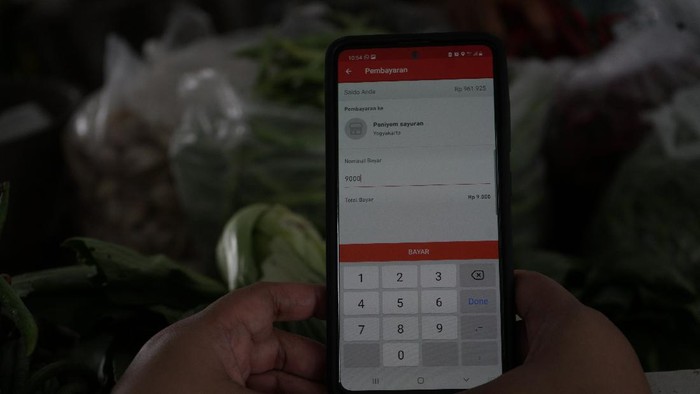 TRANSAKSI NON TUNAI DI PASAR TRADISIONAL Warga melakukan transaksi menggunakan metode bayar scan QRIS dengan aplikasi DOKU e-Wallet di Pasar Tradisional Prawirotaman, Yogyakarta, Minggu (5/9/2021). Saat ini pemerintah Yogyakarta menggencarkan transaksi non tunai di pasar tradisional seperti di Pasar Prawirotaman maupun Pasar Beringharjo. ANTARA FOTO/Andreas Fitri Atmoko/aww.