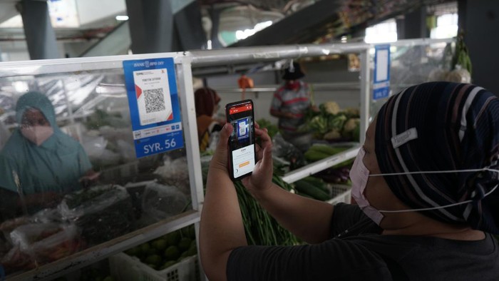 Warga melakukan transaksi menggunakan metode bayar scan QRIS dengan aplikasi DOKU e-Wallet di Pasar Tradisional Prawirotaman, Yogyakarta, Minggu (5/9/2021). Saat ini pemerintah Yogyakarta menggencarkan transaksi non tunai di pasar tradisional seperti di Pasar Prawirotaman maupun Pasar Beringharjo. ANTARA FOTO/Andreas Fitri Atmoko/aww.