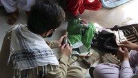 Warga tampak merapikan uang-uang kertas yang mulai lusuh.