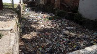 Setelah terhambat di bawah jembatan, sampah kemudian menumpuk memanjang di aliran sungai.