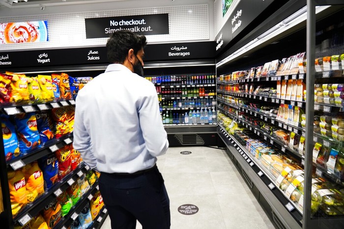 A man uses a QR code on a mobile phone to enter Carrefour's new cashier-less grocery store in Mall of the Emirates in Dubai, United Arab Emirates, Monday, Sept. 6, 2021. The Middle East on Monday got its first completely automated cashier-less store, as retail giant Carrefour rolled out its vision for the future of the industry in a cavernous Dubai mall. (AP Photo/Isabel DeBre)